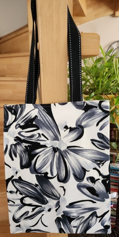 Tot bag noir et blanc à fleurs, dimensions L33 cm x H43 cm, avec sangle noire et blanche, 1 poche intérieure, vue côté 1