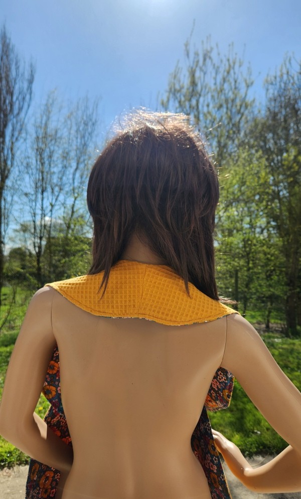 Vue arrière du châle de table élégant pour adulte, serviette croisée avec côté coton imperméable et côté nid d'abeille.