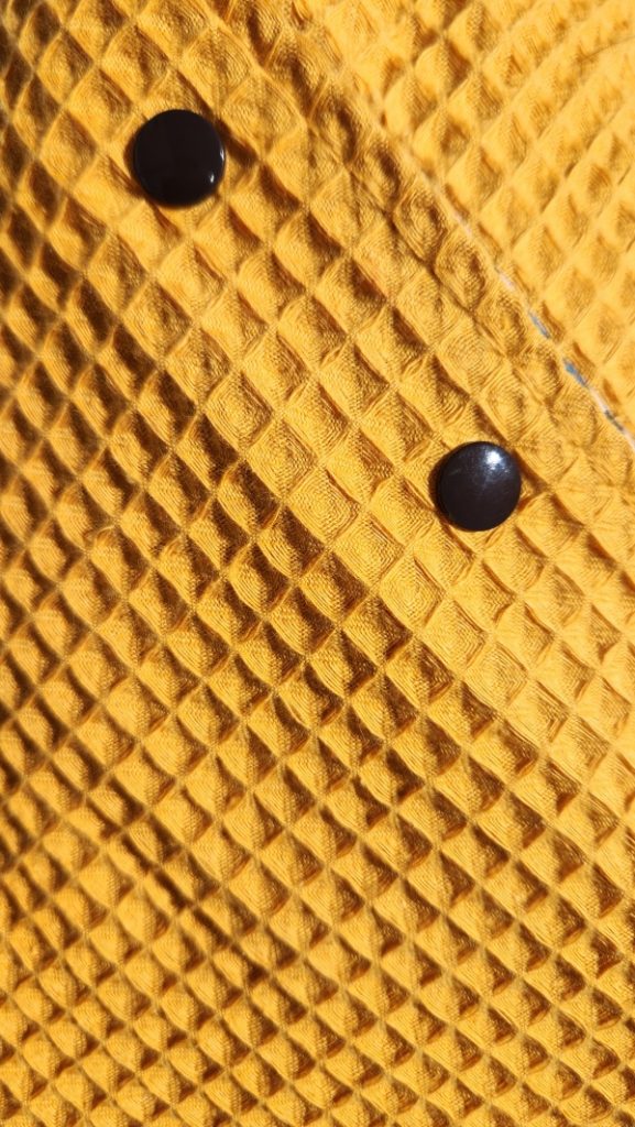 Vue du châle de table élégant pour adulte avec pressions, côté coton imperméable et côté nid d'abeille.