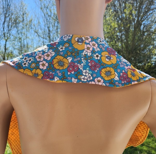 Vue arrière du châle de table élégant pour adulte, serviette croisée avec côté coton imperméable et côté nid d'abeille.