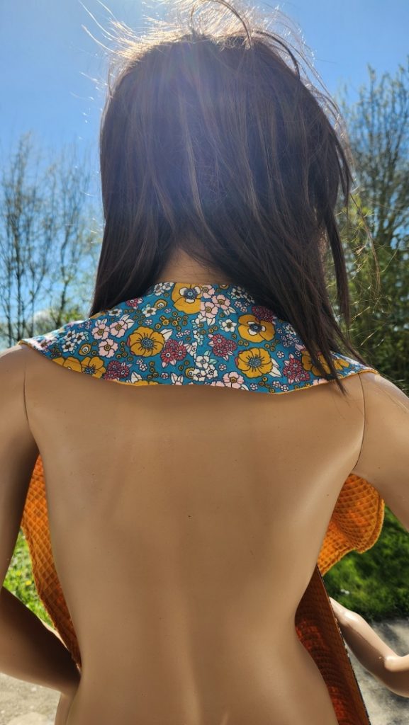 Vue arrière du châle de table élégant pour adulte, serviette croisée avec côté coton imperméable et côté nid d'abeille.