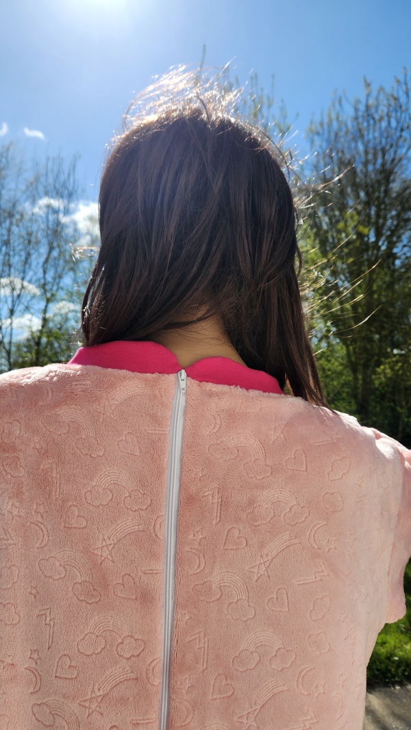 Grenouillère adaptée hiver rose avec bord côte rose pailleté, vue arrière du col et du dos, idéale pour les personnes en situation de handicap.