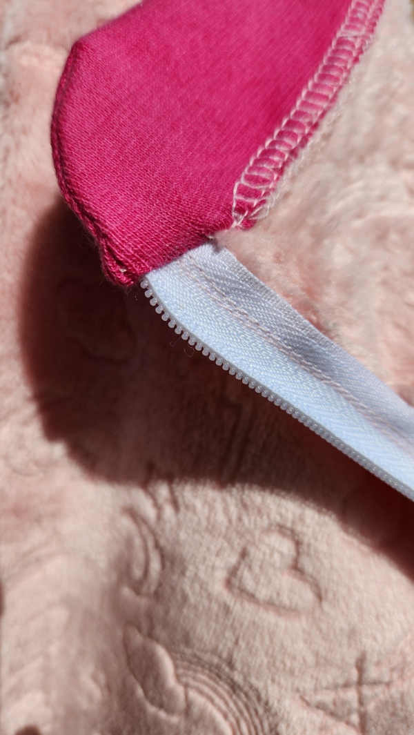 Grenouillère adaptée hiver rose avec bord côte rose pailleté et finition intérieure du col, conçue pour les personnes en situation de handicap.