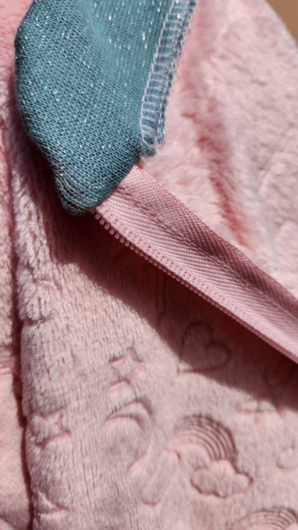 Grenouillère adaptée hiver rose avec bord côte vert pailleté, col intérieur finition soignée.
