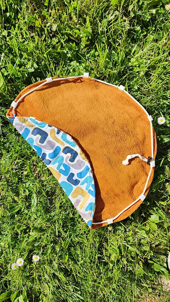 Tapis pieds au sec bleu, ocre, gris et blanc, vue de côté montrant côté éponge et imperméable, accessoire piscine-plage.