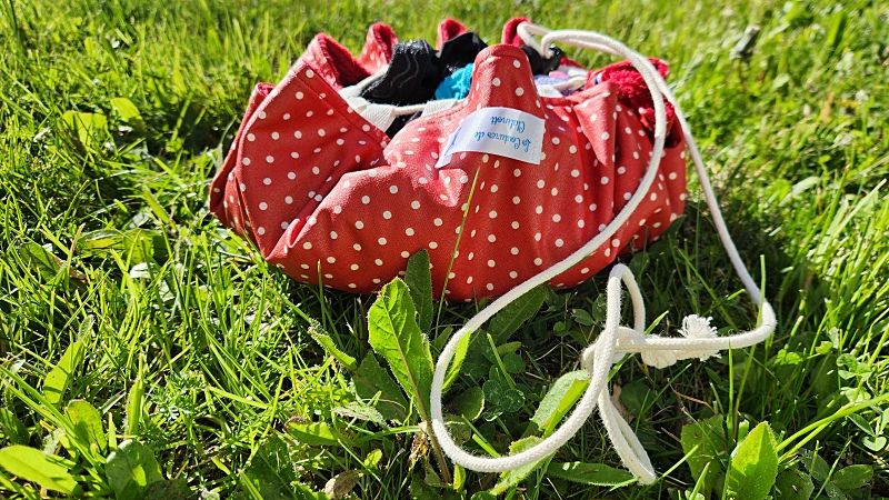 Tapis pieds au sec rouge et blanc, plié en forme de pochon, accessoire piscine-plage.